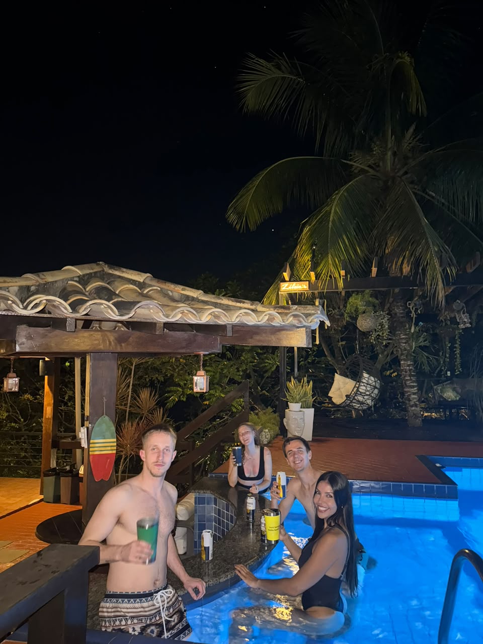 Guests with drinks in the pool at the house in Búzios at night