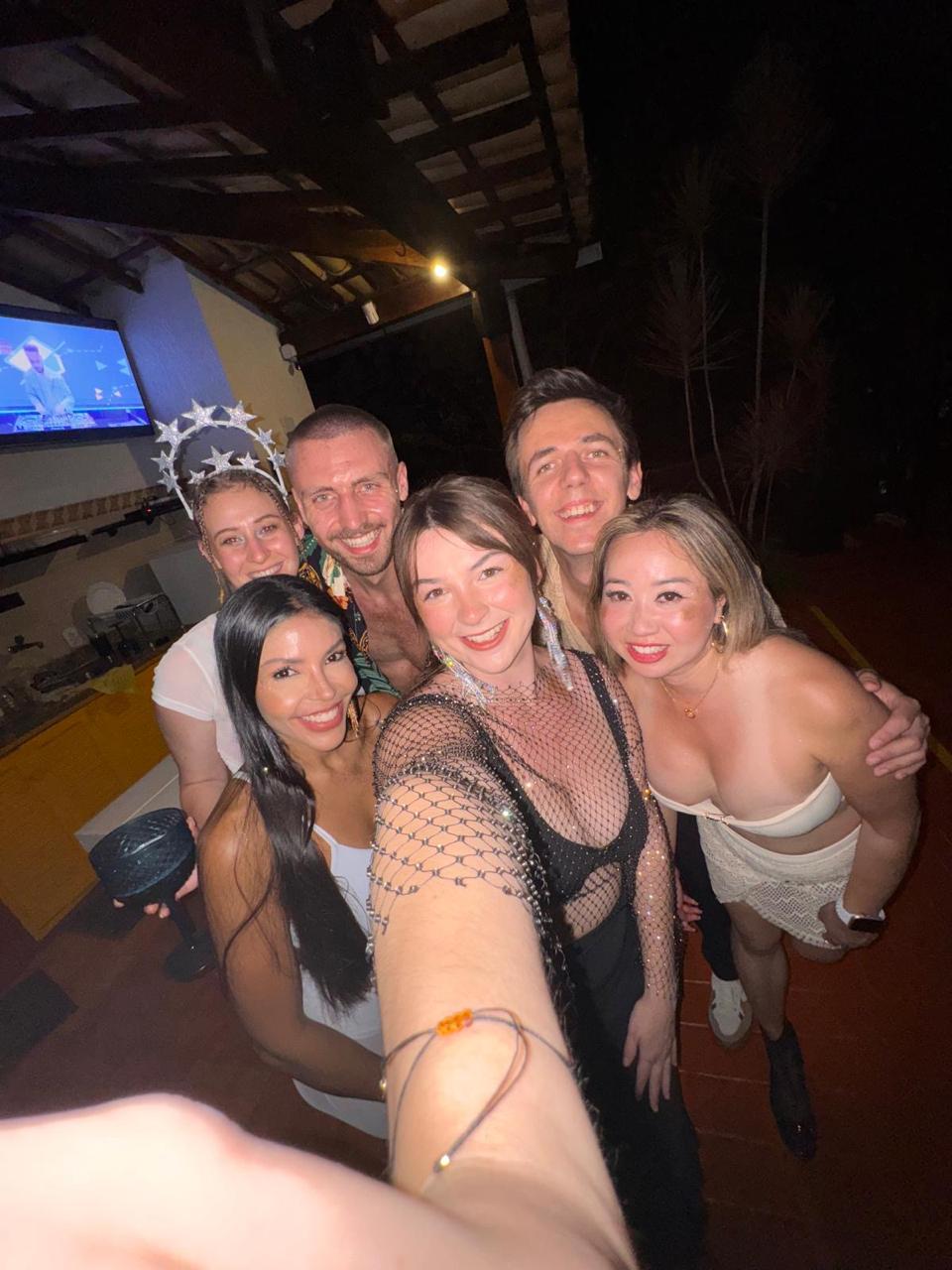 Vanessa and guests taking a selfie together at a night party in Búzios